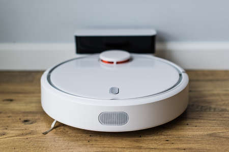 Robot vacuum cleaner on wooden floor. The view from the top. Smart home concept. Automatic cleaning.