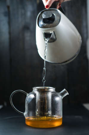The girl pours water into the teapotの写真素材