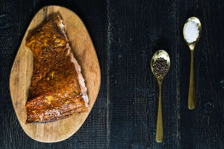 Smoked salmon fillet on black wooden background