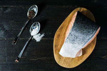 Atlantic raw salmon, steak on black wooden background.
