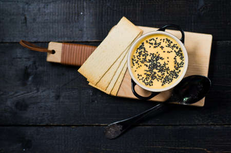 Pumpkin soup with black sesame and crackers