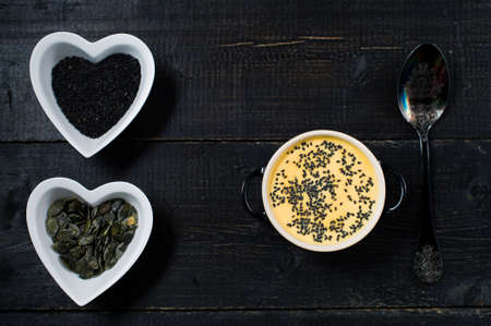 Soup pumpkin puree with seeds on a black background