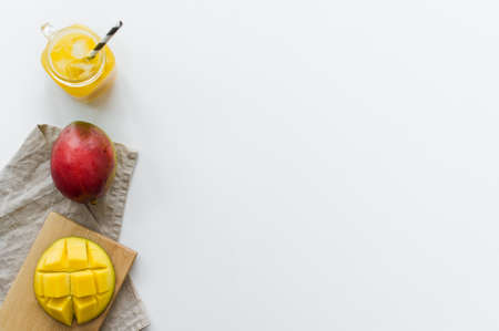 Ripe mango, half mango and a glass of mango juice on a wooden chopping Board
