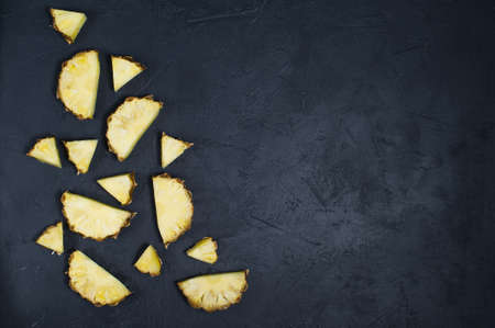 Pineapple slices on black background with space for textの写真素材