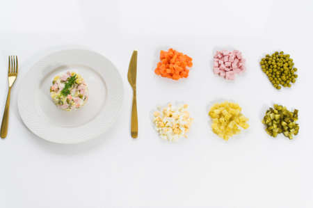 Olivier salad and ingredients for cooking on a white backgroundの写真素材