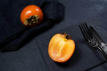 Organic bio persimmon on black backgroundの写真素材