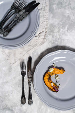 Baked pumpkin with Gorgonzola on grey plateの写真素材
