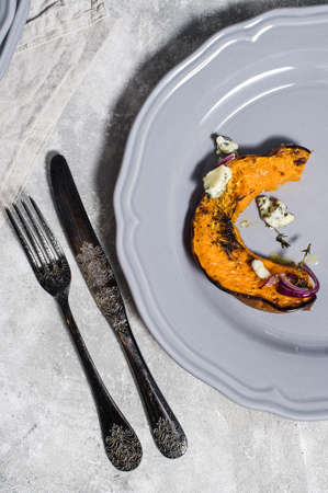 Baked pumpkin with Gorgonzola on grey plateの写真素材