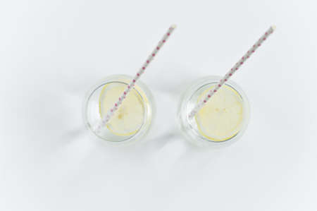 glass of clear water with lemon and strawの写真素材