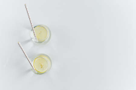 glass of clear water with lemon and strawの写真素材