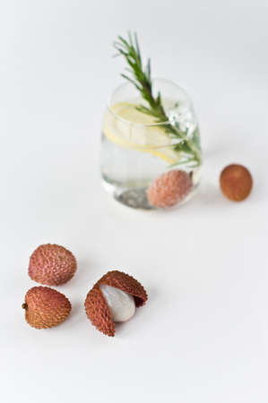 glass of clear water with lemon, rosemary, lycheeの写真素材
