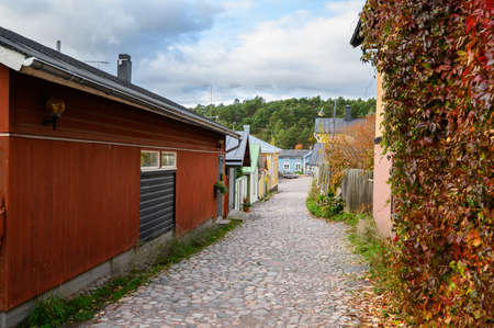 Street with cobblestones and autumn yellow and red leaves. Beautiful seasonal landscape. Porvoo, Finlandの写真素材