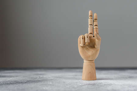 The wooden hand shows two raised fingers. The concept of communicationの写真素材