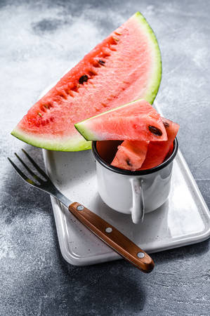 Slices of ripe watermelon on a white cutting Board. Gray background. Space for text.の写真素材