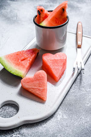 Slices of ripe watermelon in the shape of a heart. Concept of love. Gray background.の写真素材