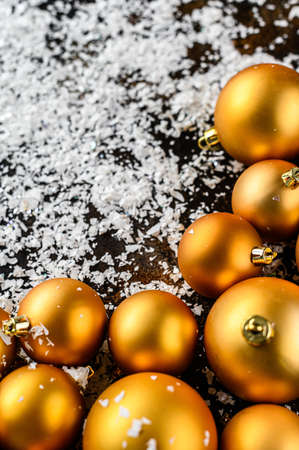 Christmas Flat Lay, new year background. Gold baubles on Dark Background, White snowflakes. Selective focus. Minimalistic design. Space for text.の写真素材