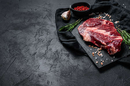 Raw black Angus steak. Organic farm beef black Angus. Black background. Space for text.