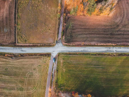 Aerial view of the intersection of two roads surrounded by fields. Photo taken from a drone. Finland, Pornainenの写真素材