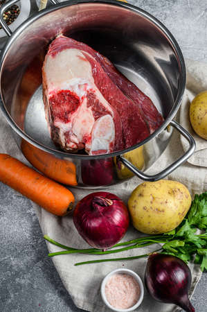 Pot with veal on the bone. Ingredients for soup, vegetables and spices. Top view.の写真素材