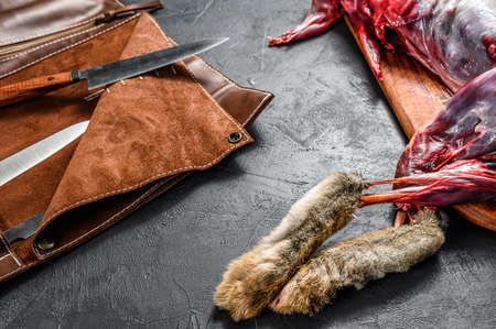 Whole forest farm hare, raw meat on wooden deck, old black rustic table. top view.の写真素材