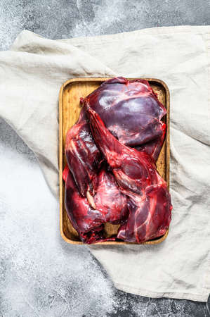 Hare meat. Raw fresh wild hare on a wooden table with vegetables and spices. Top view. Copy space.の写真素材