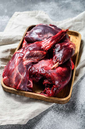 Hare meat. Raw fresh wild hare on a wooden table with vegetables and spices. Top view. Copy spacの写真素材