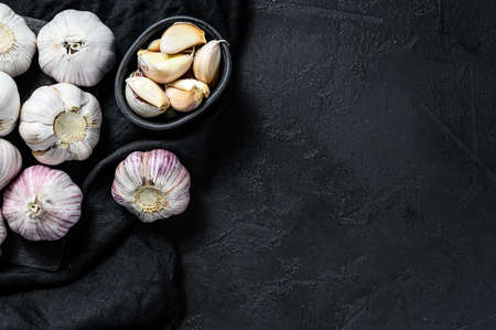 Garlic Bulb and garlic cloves on a wooden cutting Board. Organic farm food. Black background. Top view.の写真素材