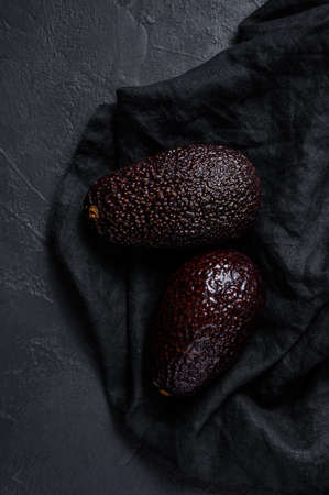 Brown ripe avocado. Black background. Top view.の写真素材