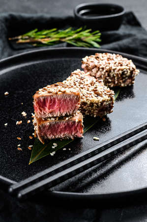 Grilled tuna steak in sesame seeds. Black background. Top viewの写真素材