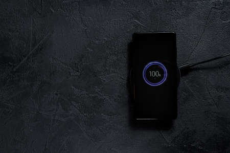 wireless charging pad for mobile phone. Black background. Top view. Space for text. 27.11.2019...