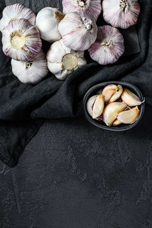 Garlic Bulb and garlic cloves on a wooden cutting Board. Organic farm food. Black background. Top...