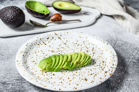 Chopped green avocado. Gray background. Top view.