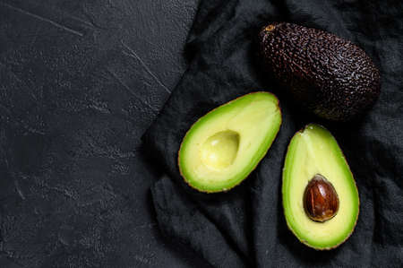 Sliced ripe avocado. Black background. Top view. Space for text.の写真素材