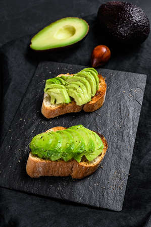 Avocado toast. Black background. Top view. Space for text.