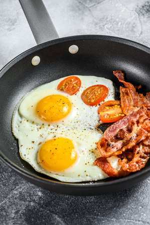 Fried eggs with bacon in a pan. Keto Diet. Keto breakfast. Low carb diet concept. high fat diet. Gray background. Top view.の写真素材