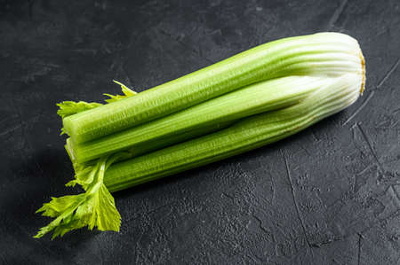 Celery vegetable on wood tray. Black background. Top view.の写真素材