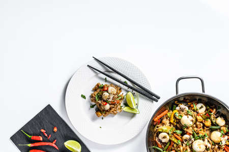 Stir fry Udon noodles with seafood and vegetables. White background. Top view. Copy space.
