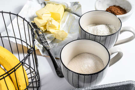 Ingredients for cooking healthy biscuit. Banana, Flour, sugar and Butter. White background. Top...