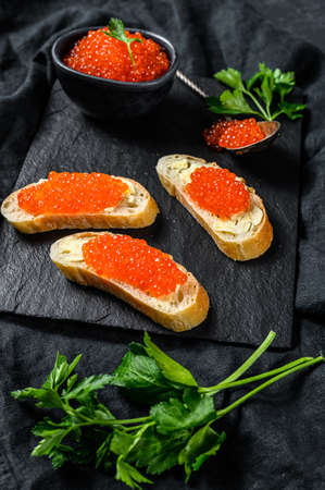 Sandwiches with salmon red caviar. Black background. Top view.の写真素材