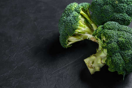 Raw green broccoli on a black background. Top view. Space for text.