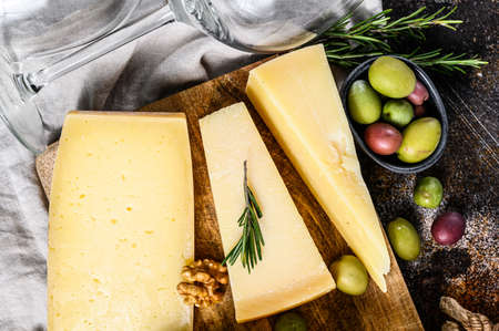 Collection of swiss, holland, french, italian cheeses with nuts and grapes. Dark background. Top view.の写真素材