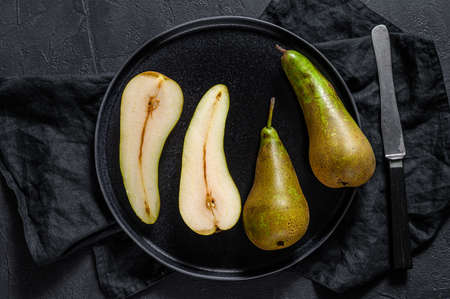 Pears and pear halves. Farm eco fruits. Black background. Top view.の写真素材