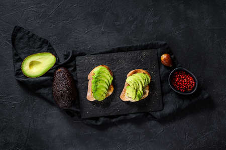 Avocado toast. Black background. Top view. Space for text.