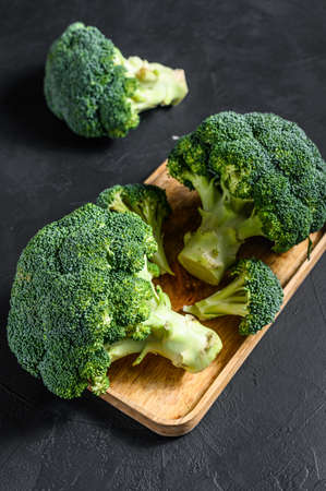 broccoli in a wooden bowl. Black background. Top view.の写真素材
