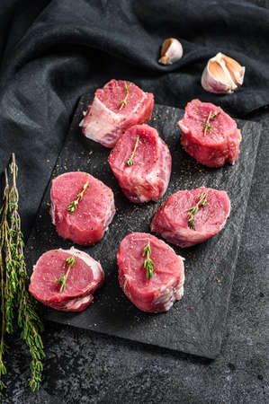 Raw pork medallion steaks. Pork meat fillet. black background. Top view.の写真素材