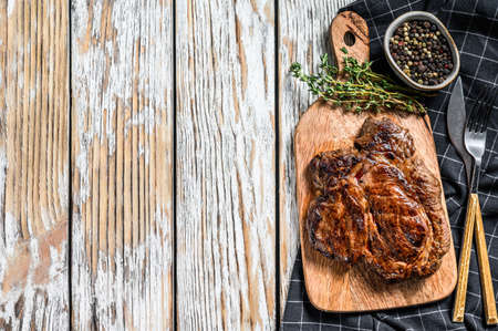 Cooked grilled Chuck eye roll steak on a chopping Board.の写真素材
