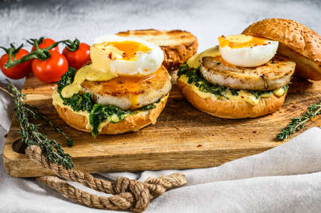 Homemade fish Burger with cod fillet, egg and spinach on a brioche bun. Gray background. Top view.の写真素材