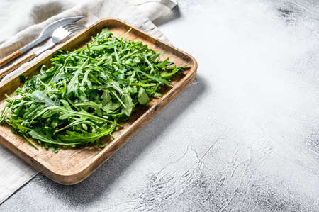 Fresh rucola salad in a wooden bowl. Gray background. Top view. Copy space.の写真素材
