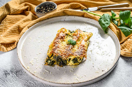 Baked Stuffed Vegetarian pasta Cannelloni with Broccoli, spinach, Basil and Cheese. Gray background. top viewの写真素材
