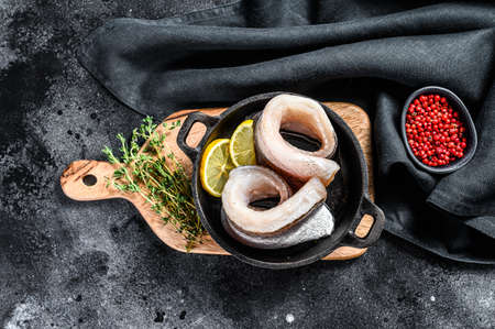 Recipe for cooking fillet of hake fish in a pan. Black background. Top view.の写真素材